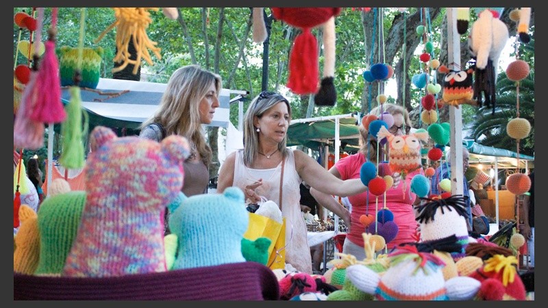 Dos mujeres observan unos peluches en un stand colorido.