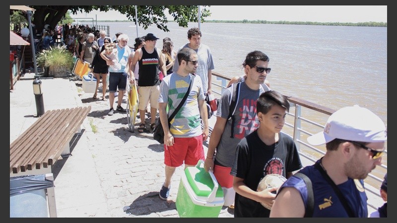 Rosarinos y turistas en una larga fila para abordar la embarcación.