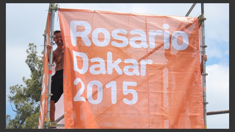 Dos jóvenes colocan los carteles que ya se pueden ver en los alrededores del Parque Independencia.