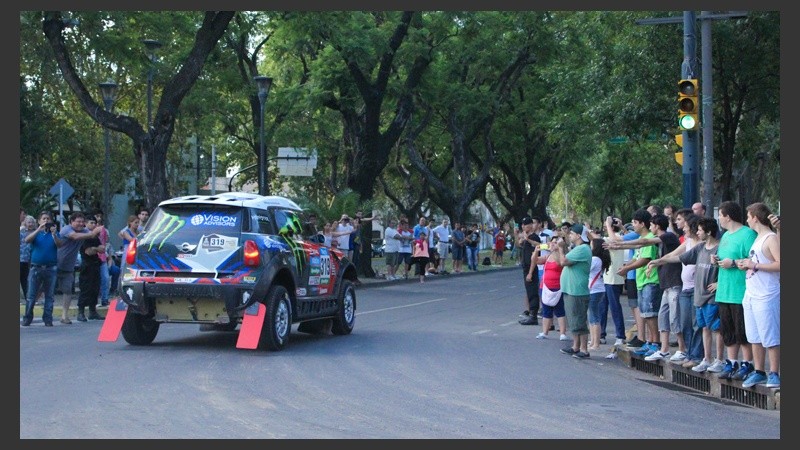 Un grupo de personas ven pasar un auto del Dakar.
