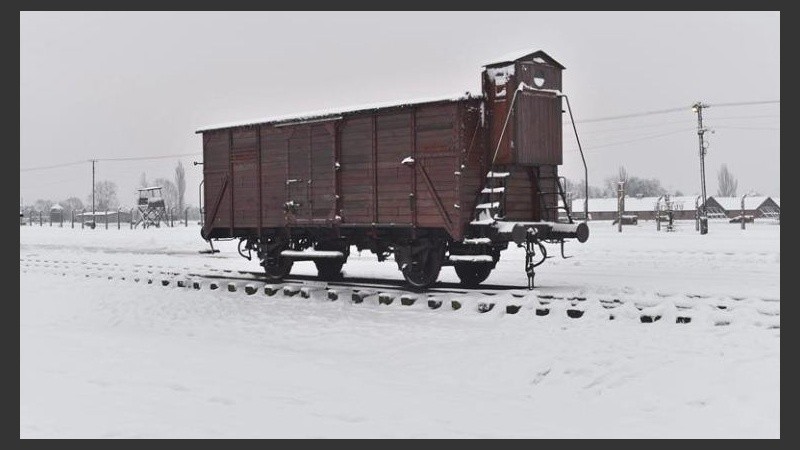 Un vagón de tren está cubierto de nieve ante el campo de concentración alemán nazi Auschwitz 