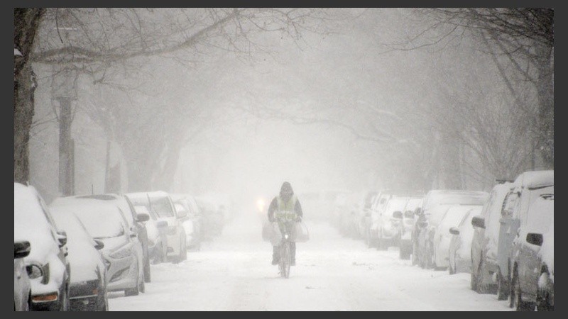 Un hombre se anima a salir bajo la nieve y el frío con su bicicleta.