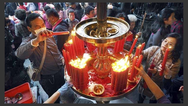 Varias personas prenden velas durante las celebraciones en Taipei (Taiwán).