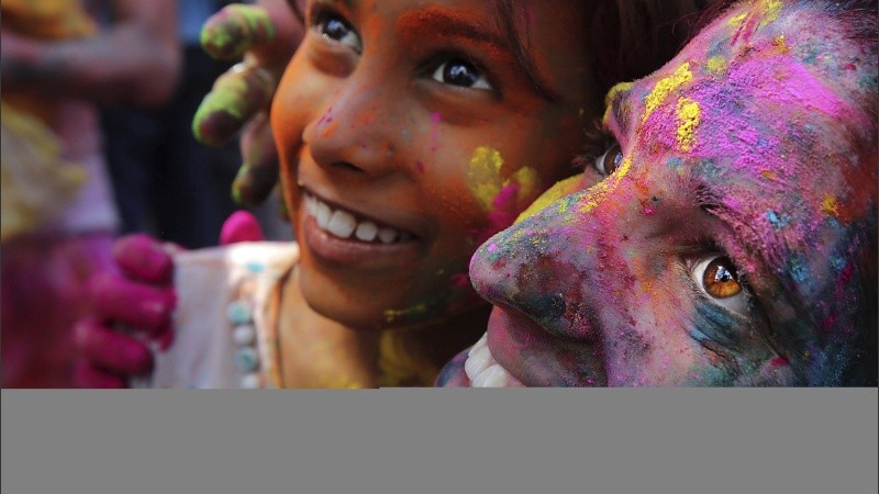 Lugareños y turistas cubiertos de polvos de colores disfrutan del Festival Holi en Calcuta.
