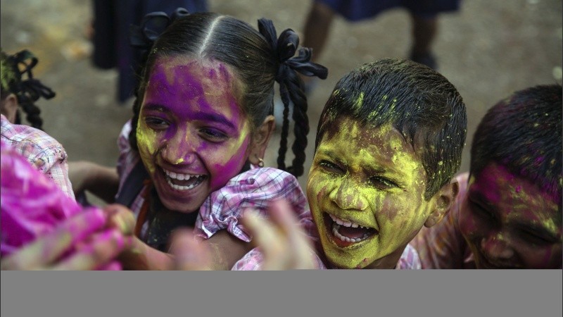  Varios estudiantes se arrojan polvos de colores mientras disfrutan del Festival Holi.