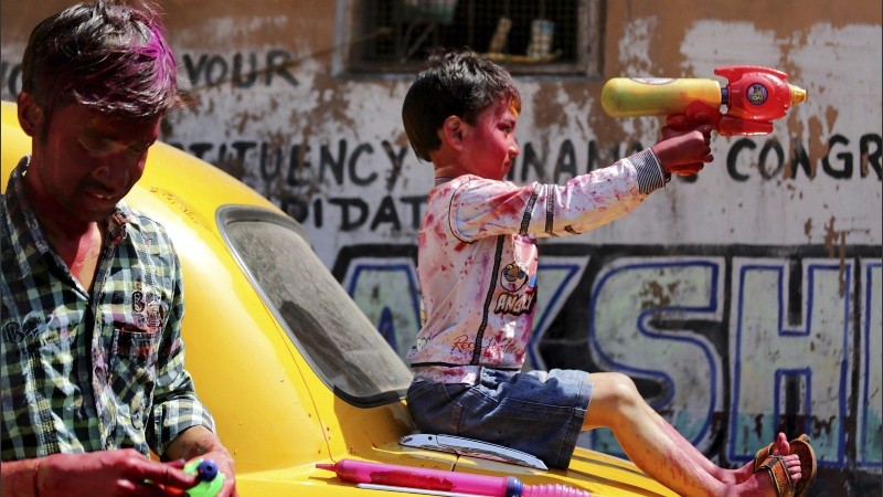 Un niño juega con una pistola de agua mientras disfruta del Festival Holi en Calcuta.