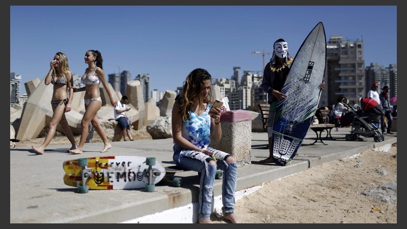 Un surfista israelí con una máscara de Guy Fawkes participa del concurso con motivo del 