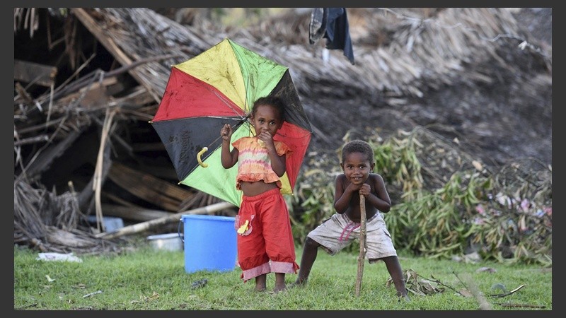 Dos niños juegan junto a las ruinas de su casa en la isla de Tanna en Vanuatu. 