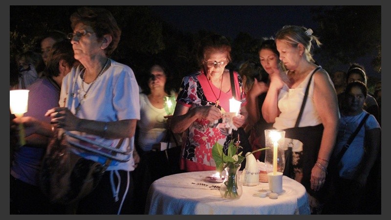 Un grupo de mujeres se detiene a rezar en un pequeño altar.