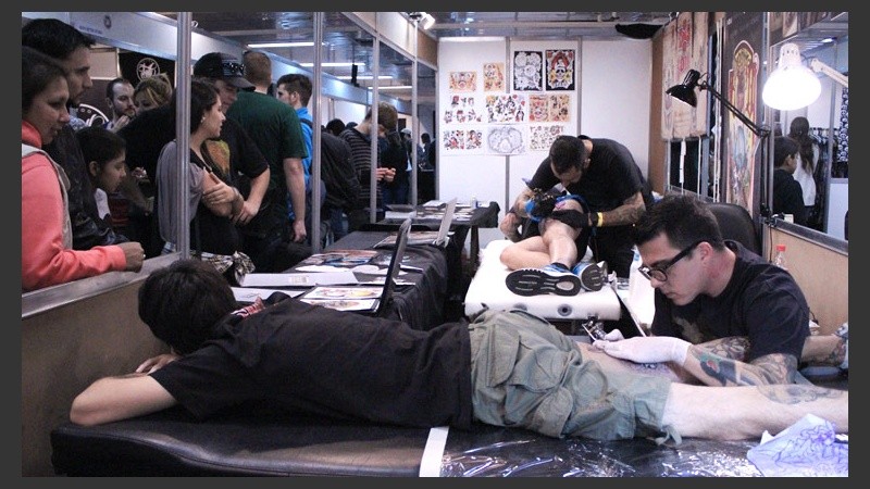 Los tatuadores trabajan a la vista de los presentes.