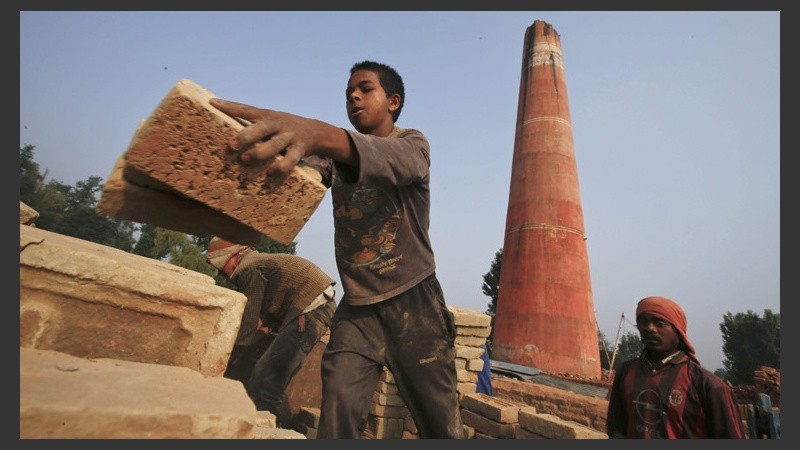 Un niño es fotografiado cargando ladrillos en una fábrica en la ciudad de Bhaktapur.