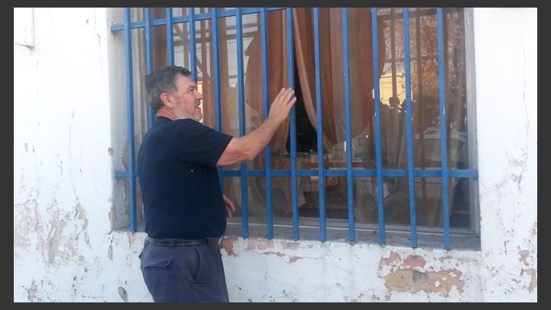 Alberto Perassi mostrando los daños en una de las ventanas.