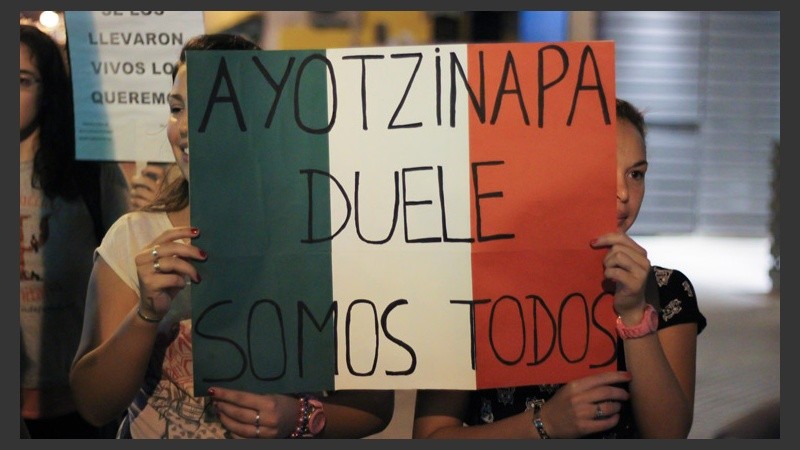 Dos mujeres sostienen un cartel de apoyo con los colores de México.