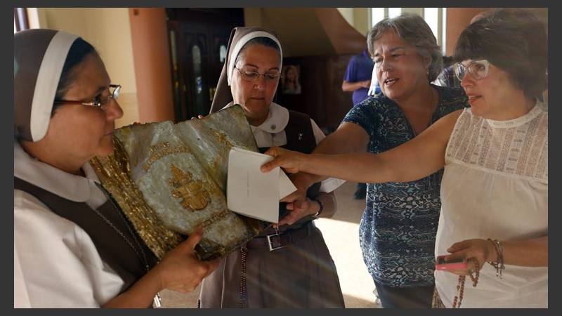 Devoción por reliquia de Juan Pablo II. Fieles en Puerto Rico miran una gota de sangre del Papa polaco.