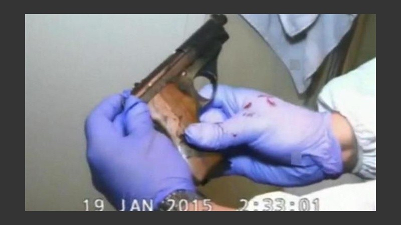 La imagen de un perito manipulando el arma que estaba con el cuerpo de Nisman.
