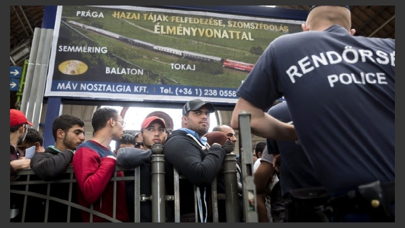 Inmigrantes esperan en una estación de trenes de Hungría.