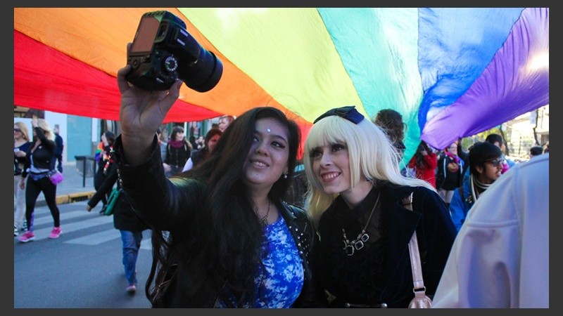Dos chicas toman una foto bajo la gran bandera desplegada por las calles rosarinas. (Alan Monzón/Rosario3.com)