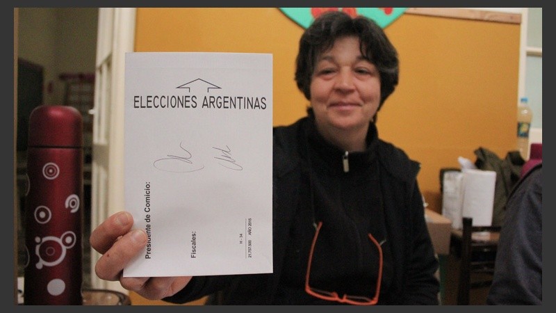 Una autoridad de mesa muestra uno de los sobres donde la gente colocaba las boletas. (Rosario3.com)