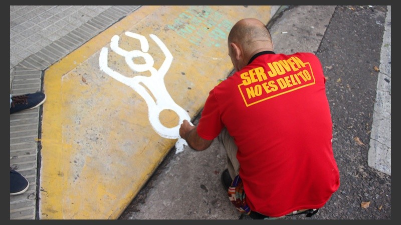 Uno de los militantes realiza una pintada en la puerta del Concejo. (Alan Monzón/Rosario3.com)