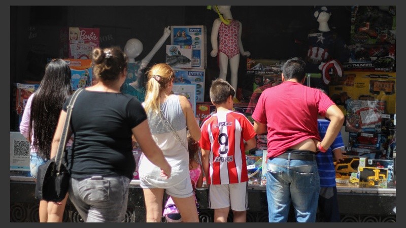 Una familia observa una vidriera repleta de juguetes. (Rosario3.com)