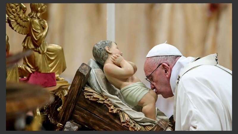 El Papa besando los pies de la imagen del Niño Jesús. (EFE)