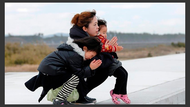 Una mujer y sus hijos rezan en memoria de las víctimas del terremoto y posterior tsunami de hace cinco años en Arahama en Sendai. 