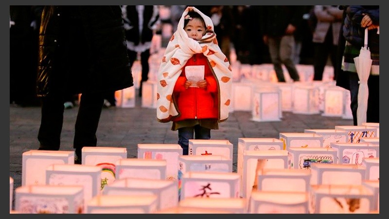  Una niña observa varias linternas de papel durante una ceremonia en conmemoración de las víctimas del terremoto y posterior tsunami. 