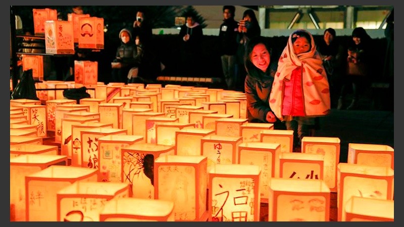 Una mujer y su hija observan varias linternas de papel durante una ceremonia en conmemoración de las víctimas del terremoto y posterior tsunami.