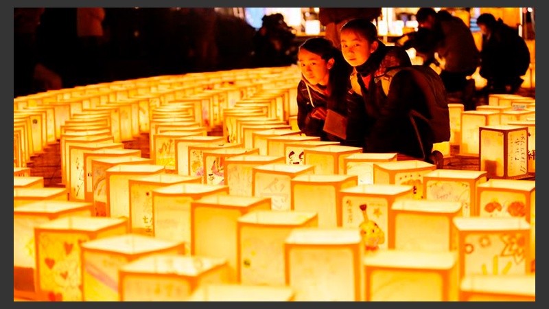 Las jóvenes Fuuka y Asena Takakeda observan varias linternas de papel durante una ceremonia en conmemoración de las víctimas del terremoto y posterior tsunami.
