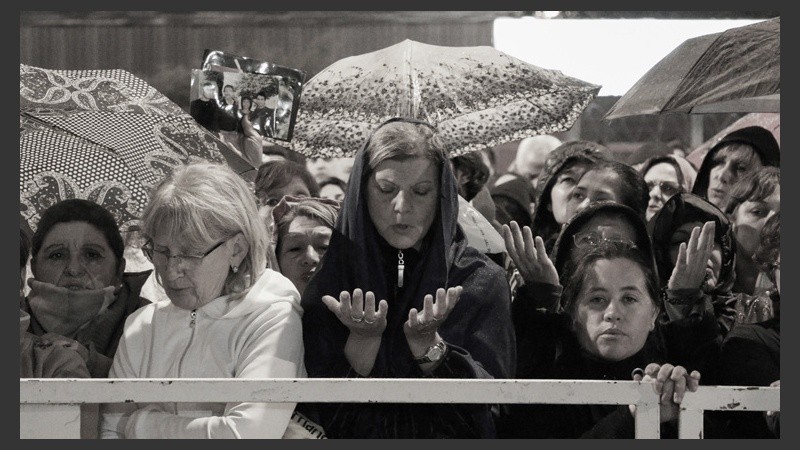 Creyentes durante una oración. La lluvia se hizo presente por algunos minutos. (Alan Monzón/Rosario3.com)