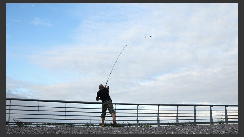 Un pescador en pleno lanzamiento. Son muchos los rosarinos que se acercan a la costa a pescar. (Alan Monzón/Rosario3.com)