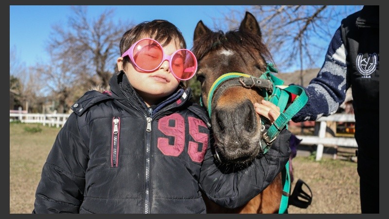 Un pequeño posa para la foto junto a su caballo. La interacción entre ambos es la clave del método terapéutico. (Alan Monzón/Rosario3.com)