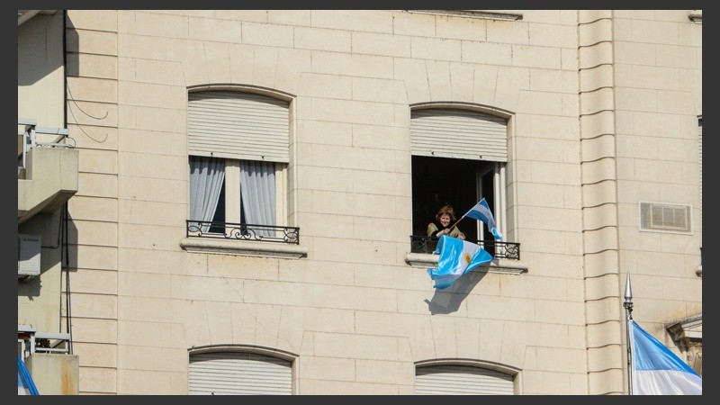 Una señora flamea su bandera asomada desde la ventana de su departamento frente al Monumento. (Alan Monzón/Rosario3.com)