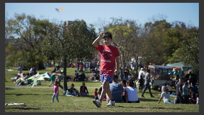 Un joven sonríe tras remontar su barrilete este domingo en el parque.