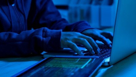 Wanted hackers coding virus ransomware using laptops and computers. Cyber attack, system breaking and malware concept.