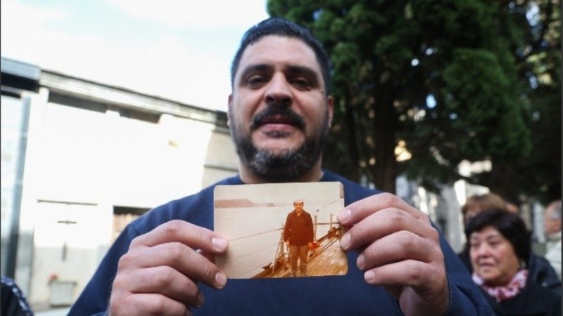 Santiago Gallo con la foto de su padre, Felipe, que le entregaron en el funeral más largo por Malvinas.