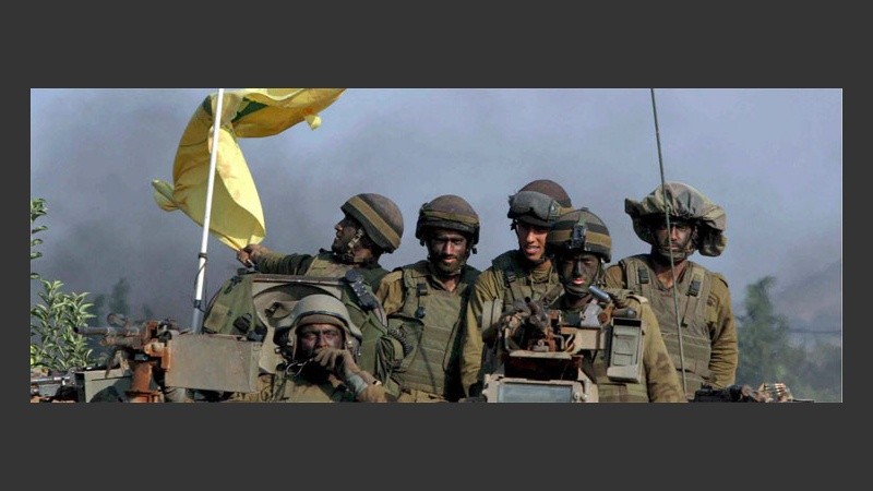 Soldados israelíes muestran trofeo de guerra: una bandera de Hezbolá (EFE).