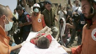 Personal de la Cruz Roja revisa a un niño sobreviviente (EFE).