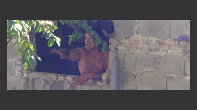 El supuesto violador en la ventana desde la que discutía con los vecinos.