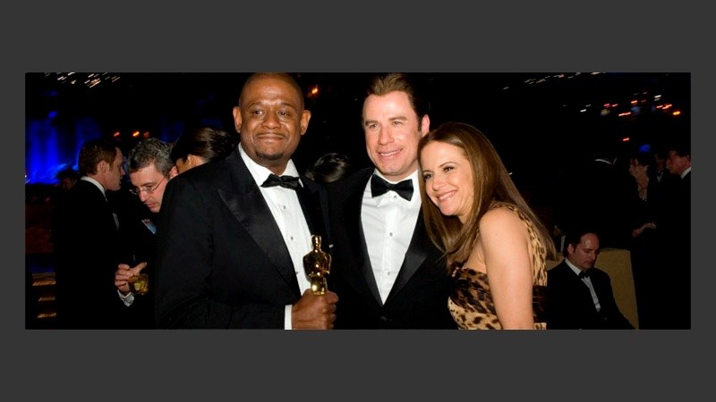 Forest Whitaker, elegido mejor actor, celebra junto a John Travolta y su esposa (EFE).