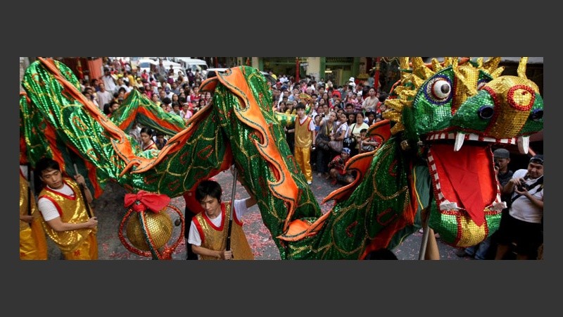 Bailarines llevan un dragón para anunciar la llegada del período del Tigre.