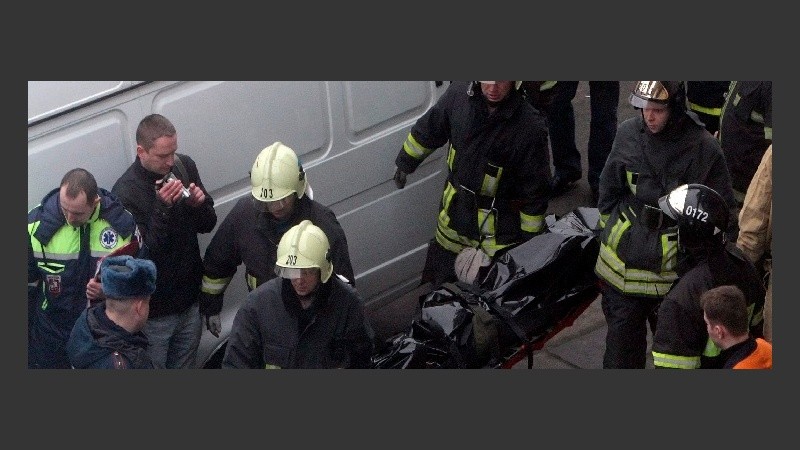 Servicios de rescate evacúan los cadáveres de las víctimas. 