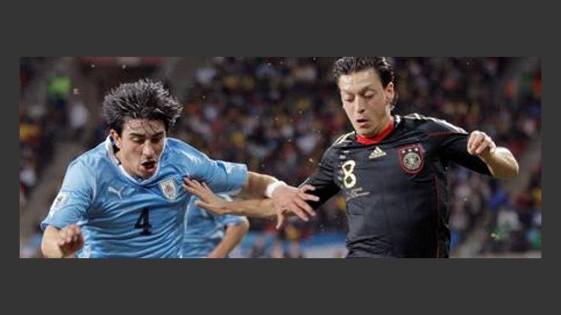 Özil, una de las figuras del Mundial, pelea el balón con Fucile.