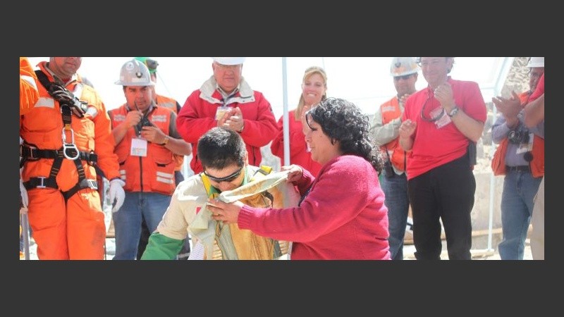 Estebán Rojas, de 44 años, se arrodilla junto a su esposa en la superficie; fue el 18º.