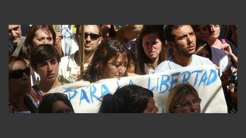 Stella junto a su hijo y la bandera con la letra de la canción que cantaba en El Pozo 
