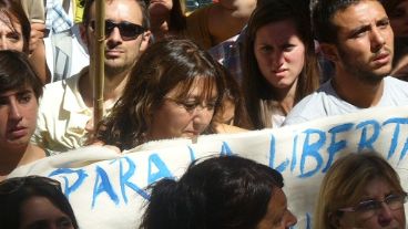 Stella junto a su hijo y la bandera con la letra de la canción que cantaba en El Pozo "para vivir".