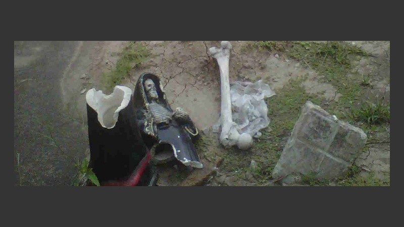 Una estatua de San La Muerte y un fémur, parte del ritual hecho en el cementerio.