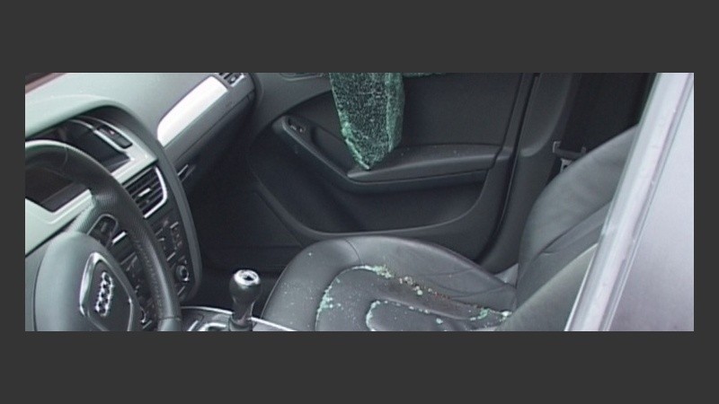 El interior del vehículo con los vidrios rotos por el asalto.