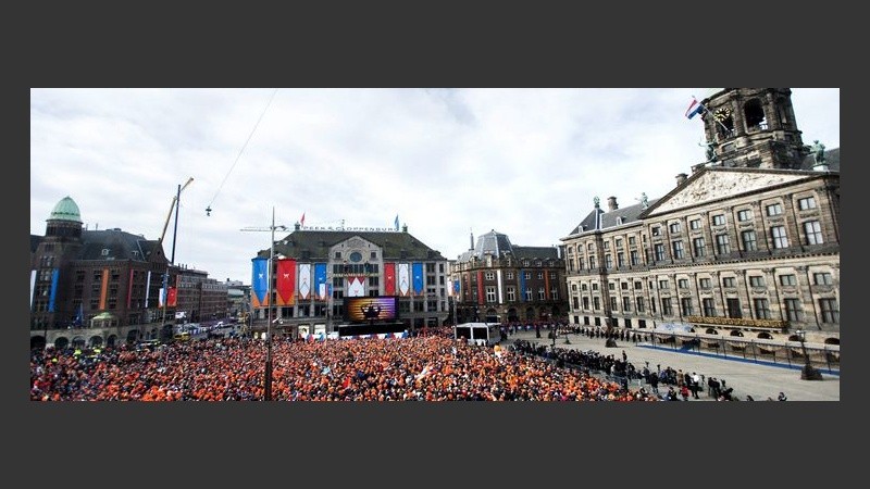 Una multitud con coronas naranjas se reúne en la plaza Dam