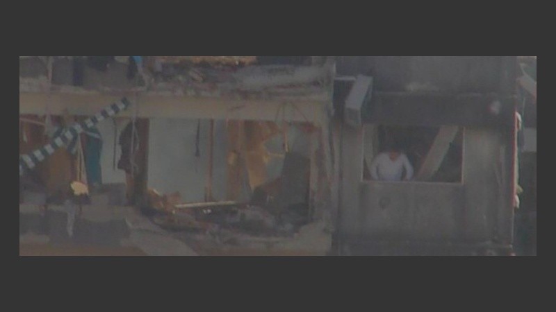 Un hombre asomado al edificio que explotó. 